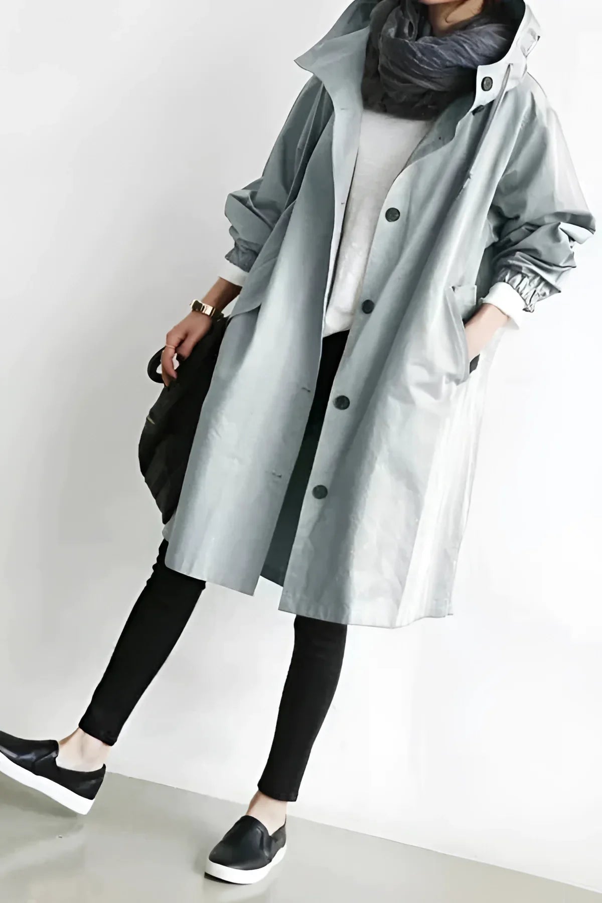 Stylish oversized gray women's hooded waterproof raincoat with urban chic design, close-up of model's upper body showcasing the hood and chest area.